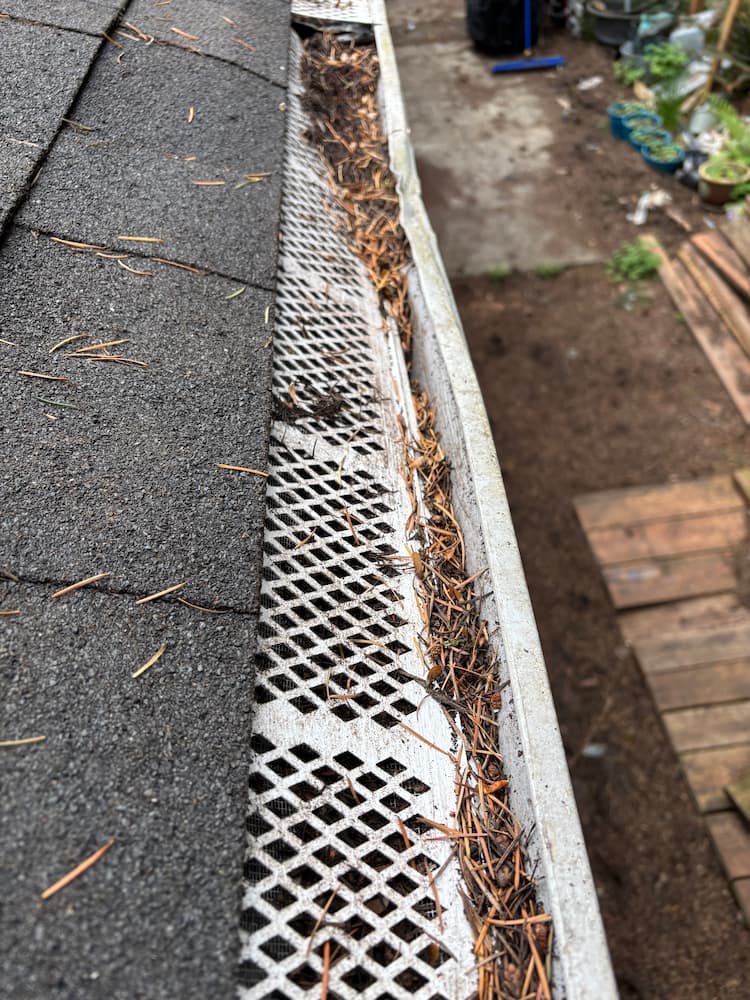 Example of incorrectly installed gutter guard causing drainage problems