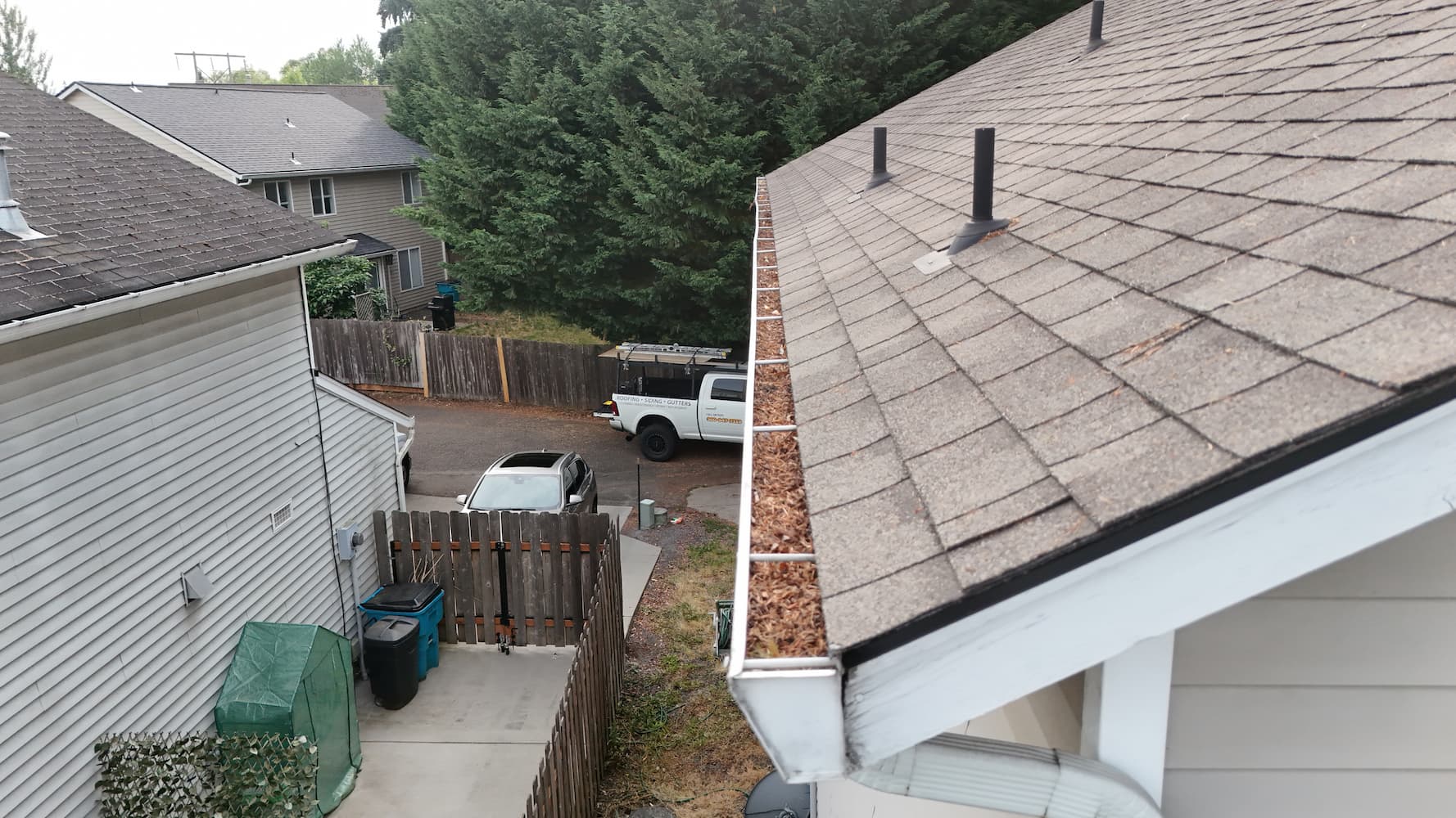 Gutter filled with leaves and pine needles causing water backup