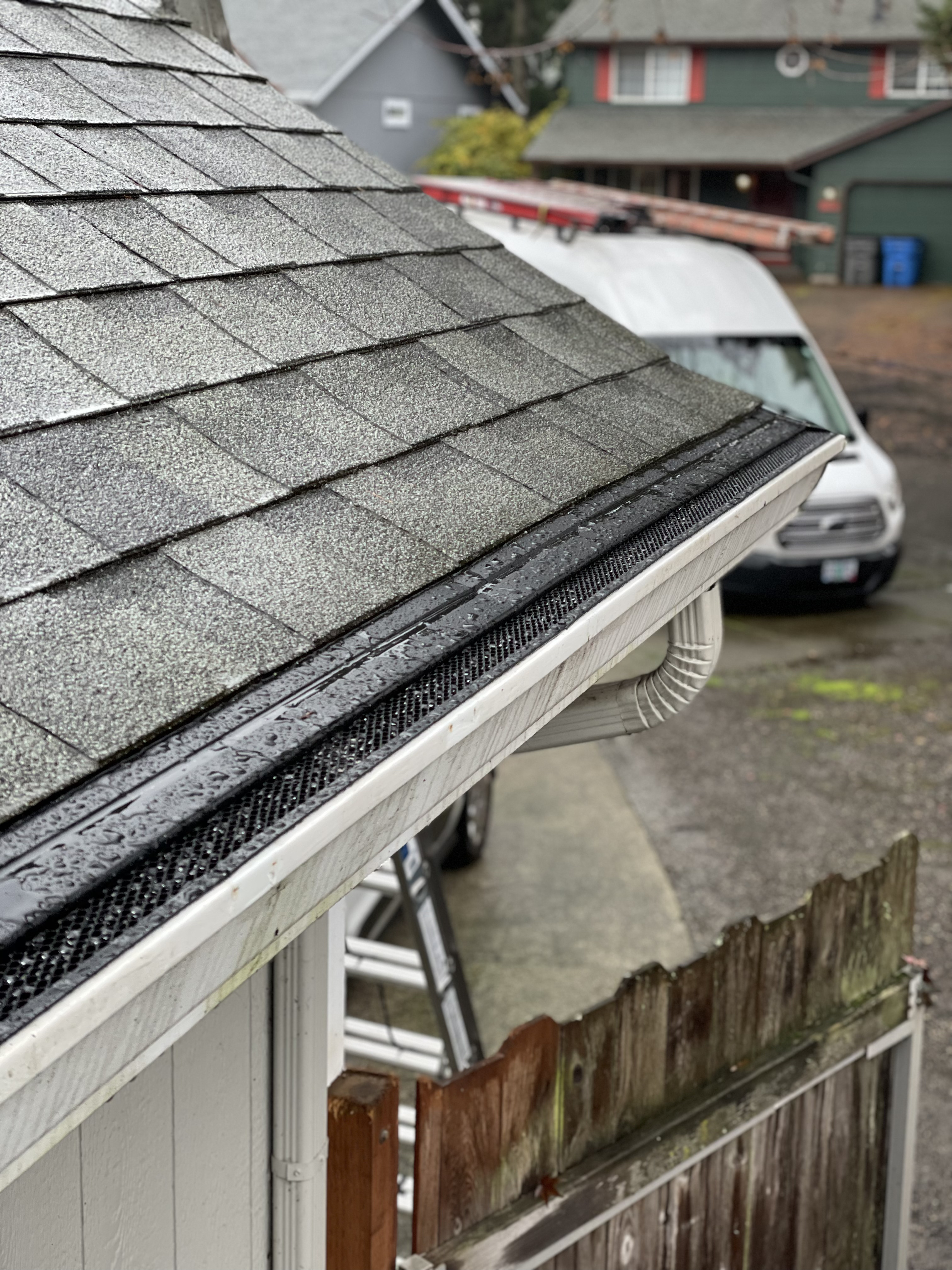 Close-up of Premier louvered gutter guards showing the angled aluminum design that handles heavy rainfall