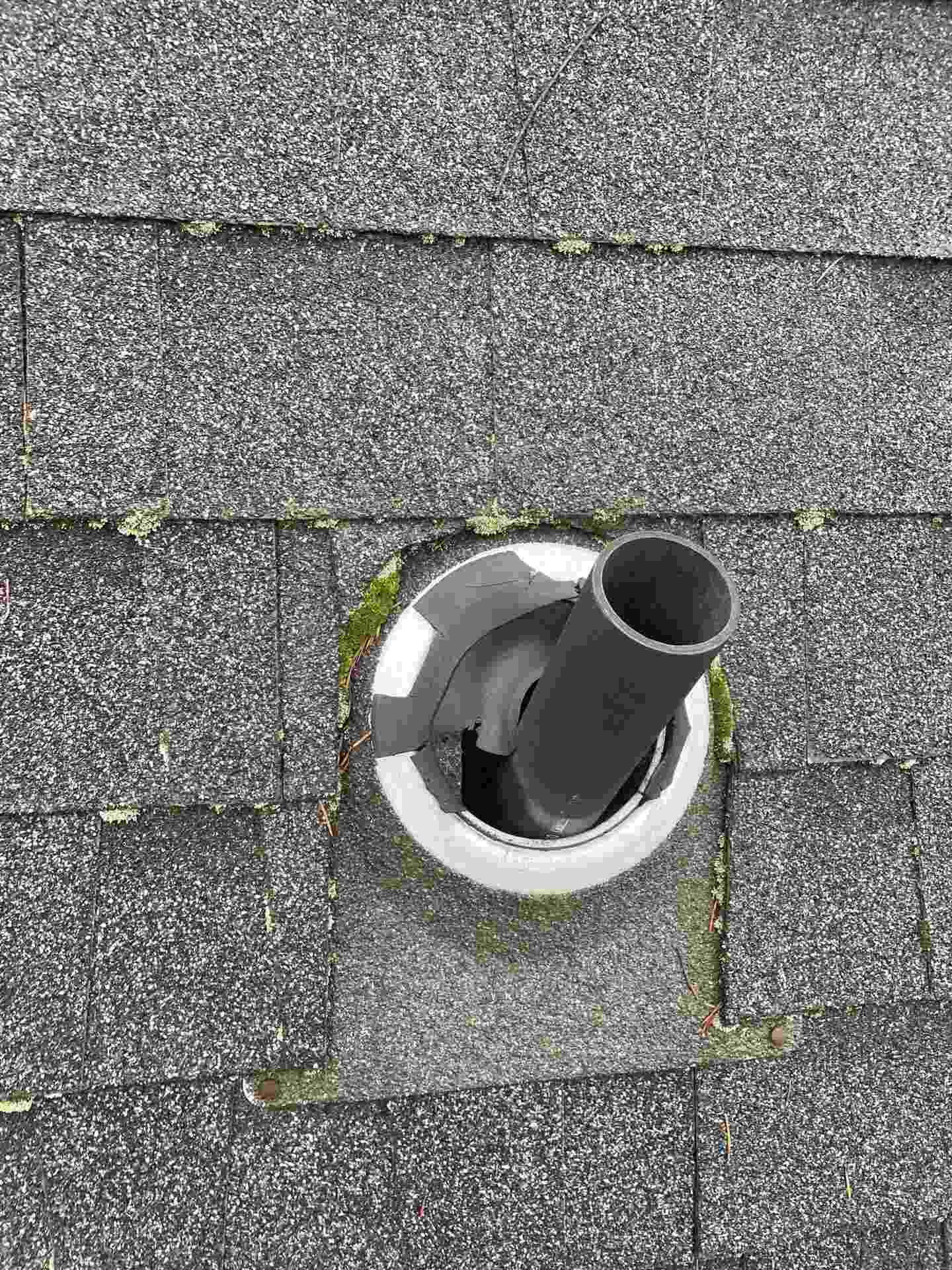 Real roof maintenance finding: bent and damaged metal vent cap on a plumbing vent pipe with moss and debris around the base on a Vancouver WA home